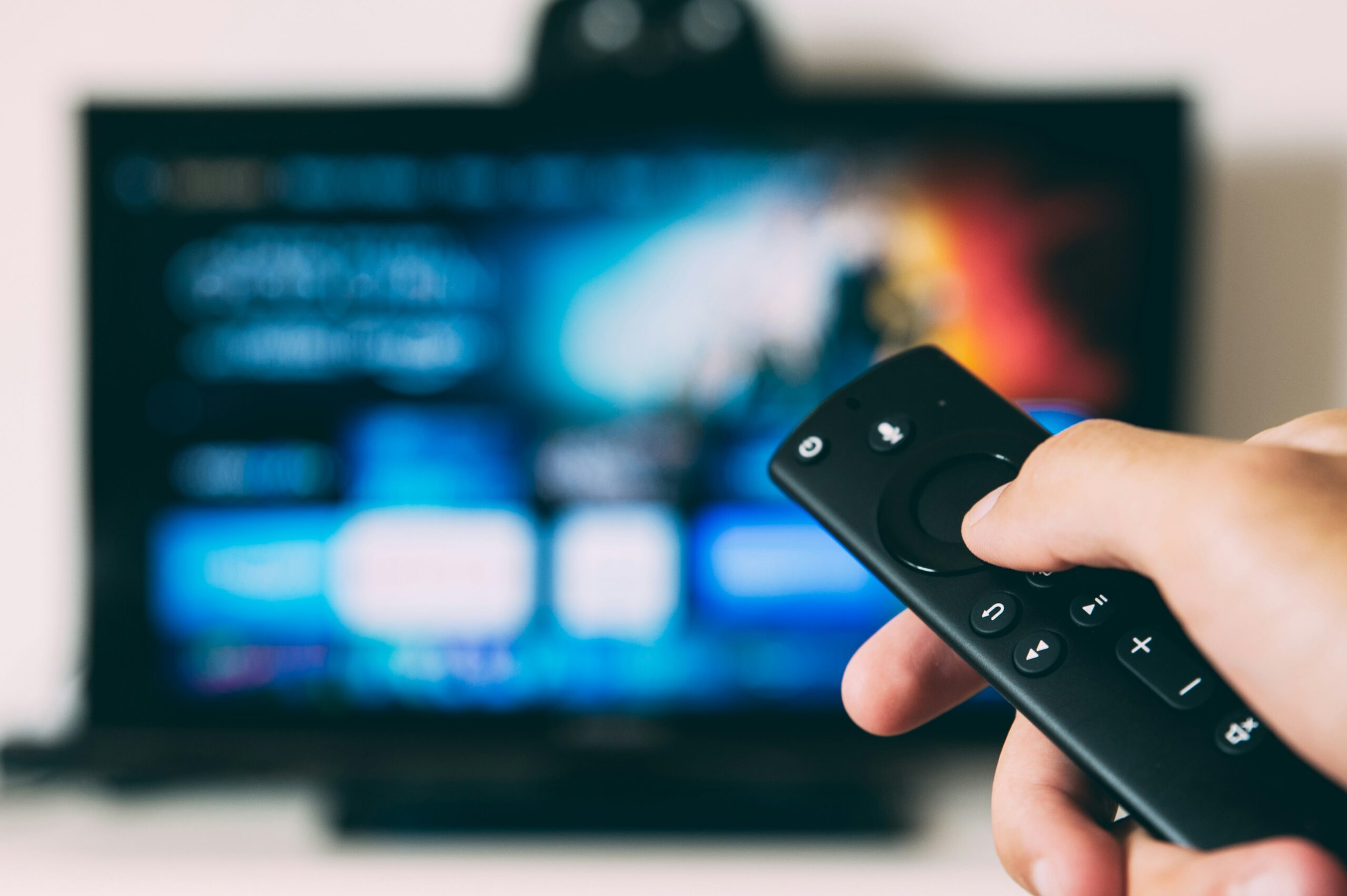 Hand pointing remote at TV. how to negotiate your bills and subscriptions