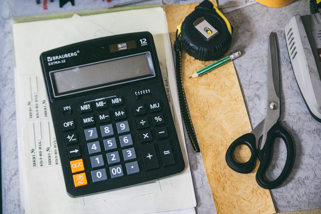 Calculator, home repair tools, and seasonal maintenance checklist on wooden table