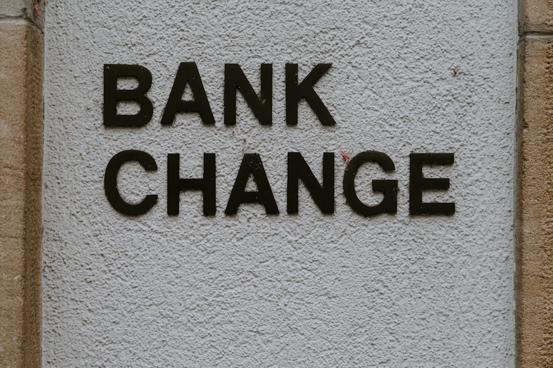 Divorced couple reviewing bank documents to close joint account with banker assistance