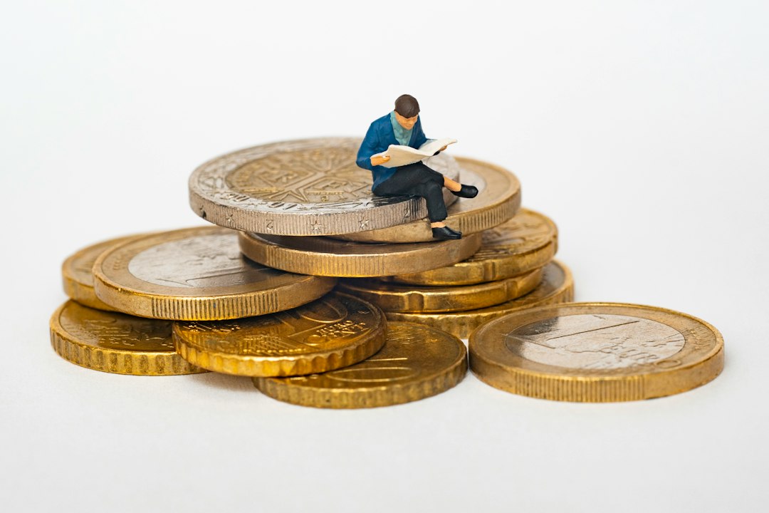 Stack of coins beside a growing plant and open book symbolizing financial literacy