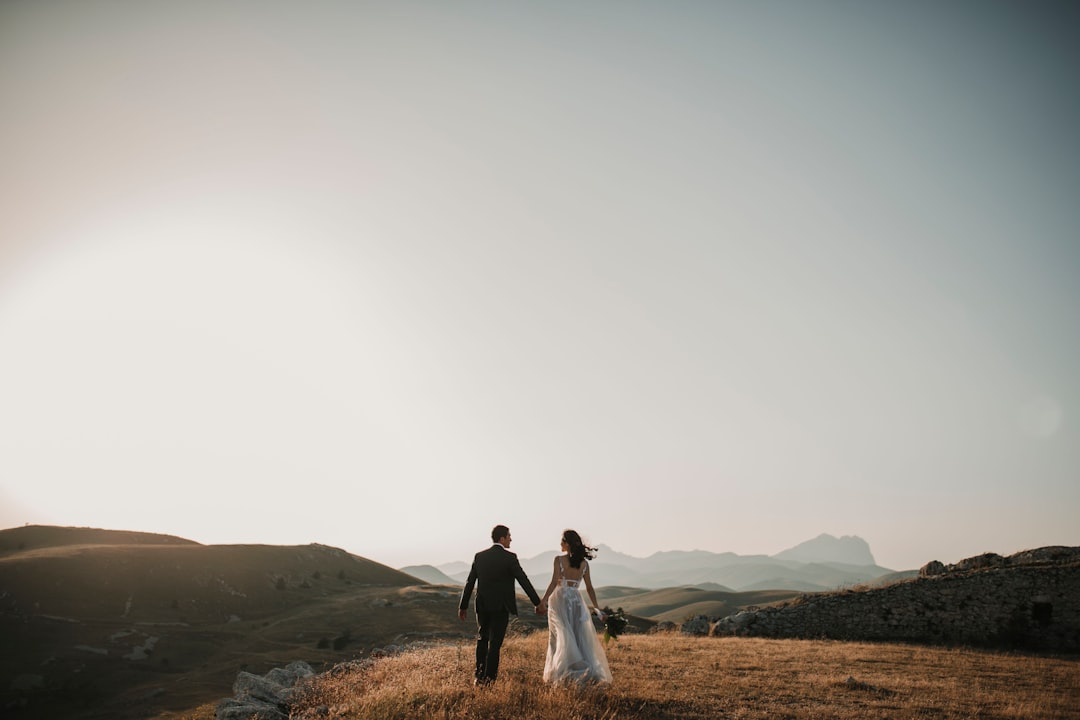Couple reviewing wedding budget spreadsheet and receipts at a table