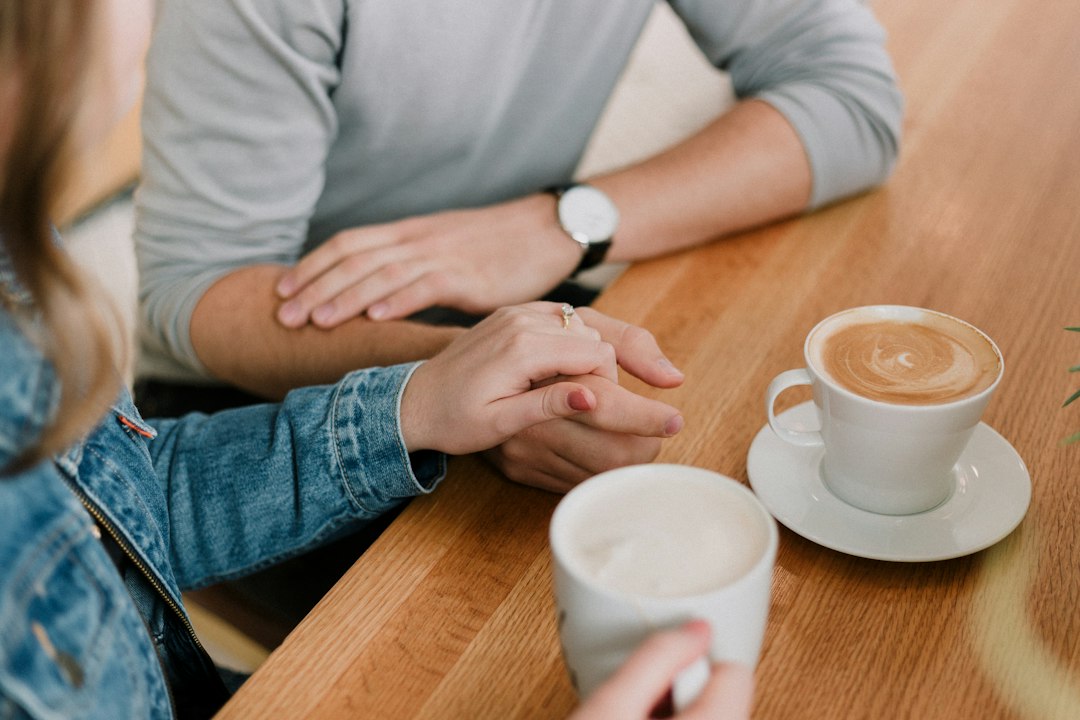 Couple smiling while discussing finances together at a kitchen table